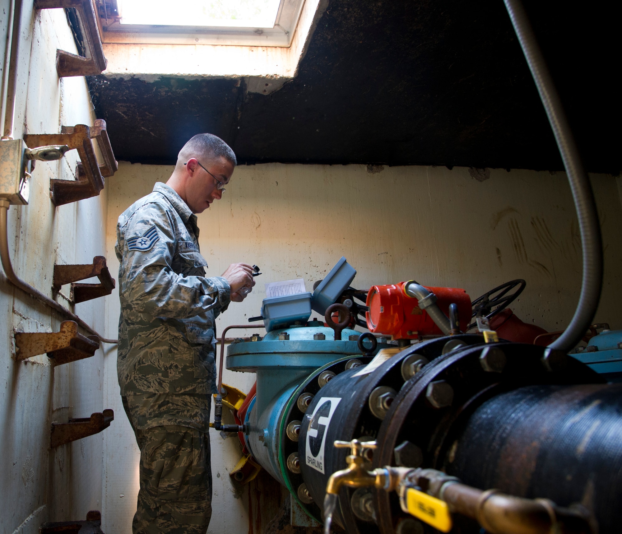 ALTUS AIR FORCE BASE, Okla. -- Staff Sgt. Marshall Varrato, 97th Medical Operations Squadron bioenvironmental engineering NCO in charge of readiness and training, prepares to perform a routine water sampling at the main water line on base. Members of the 97th MDOS bioenvironmental engineering flight conduct water samplings twice a month. The base drinking water comes from the City of Altus Water Treatment Plant. The base does not conduct further treatments of the water. (U.S. Air Force photo by Senior Airman Kenneth W. Norman / Released)