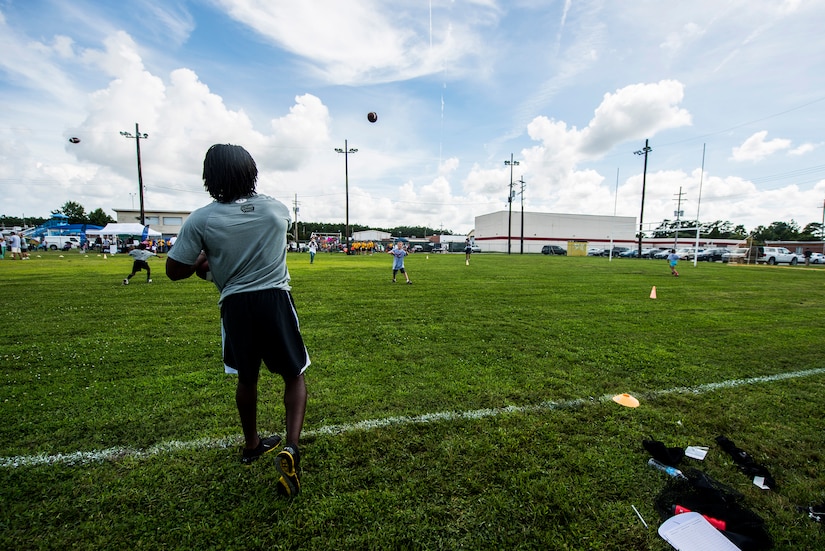 Andre Roberts, Arizona Cardinals wide receiver, throws the ball to a child during the Andre Roberts Pro Camp, July 15, 2013, at Joint Base Charleston - Weapons Station, S.C. More than 100 base children attended the Andre Roberts Pro Camp on July 15-16. The camp was paid for by Roberts, enabling the children to attend for free. (U.S. Air Force photo/ Senior Airman George Goslin)