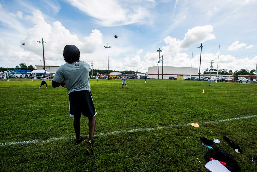 Andre Roberts, Arizona Cardinals wide receiver, throws the ball to a child during the Andre Roberts Pro Camp July 15, 2013, at Joint Base Charleston - Weapons Station, S.C. More than 100 base children attended the camp held July 15-16, and were able to participate in fundamental football drills. Small groups ensured each camper received maximum instruction from the area’s top football coaches. Roberts funded the camp, enabling children to attend for free.  (U.S. Air Force photo/ Senior Airman George Goslin)
