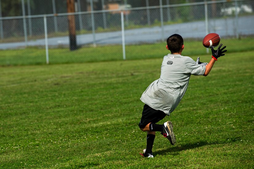 Tyler Deveau, son of Staff Sgt. Jason Deveau, 437th Aircraft Maintenance Squadron jet engine technician, catches the ball during the Andre Roberts Pro Camp, July 15, 2013, at Joint Base Charleston - Weapons Station, S.C. More than 100 base children attended the Andre Roberts Pro Camp on July 15-16. The camp was paid for by Roberts, enabling the children to attend for free. (U.S. Air Force photo/ Senior Airman George Goslin)