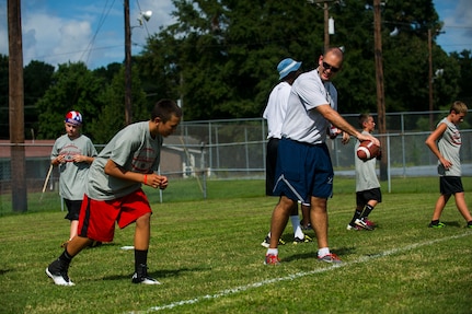 1st Lt. Matt Coates, 437th Operations Support Squadron chief of intelligence readiness, prepares to throw a ball to a child during the Andre Roberts Pro Camp, July 15, 2013, at Joint Base Charleston - Weapons Station, S.C. More than 100 base children attended the Andre Roberts Pro Camp on July 15-16. The camp was paid for by Roberts, enabling the children to attend for free. (U.S. Air Force photo/ Senior Airman George Goslin)