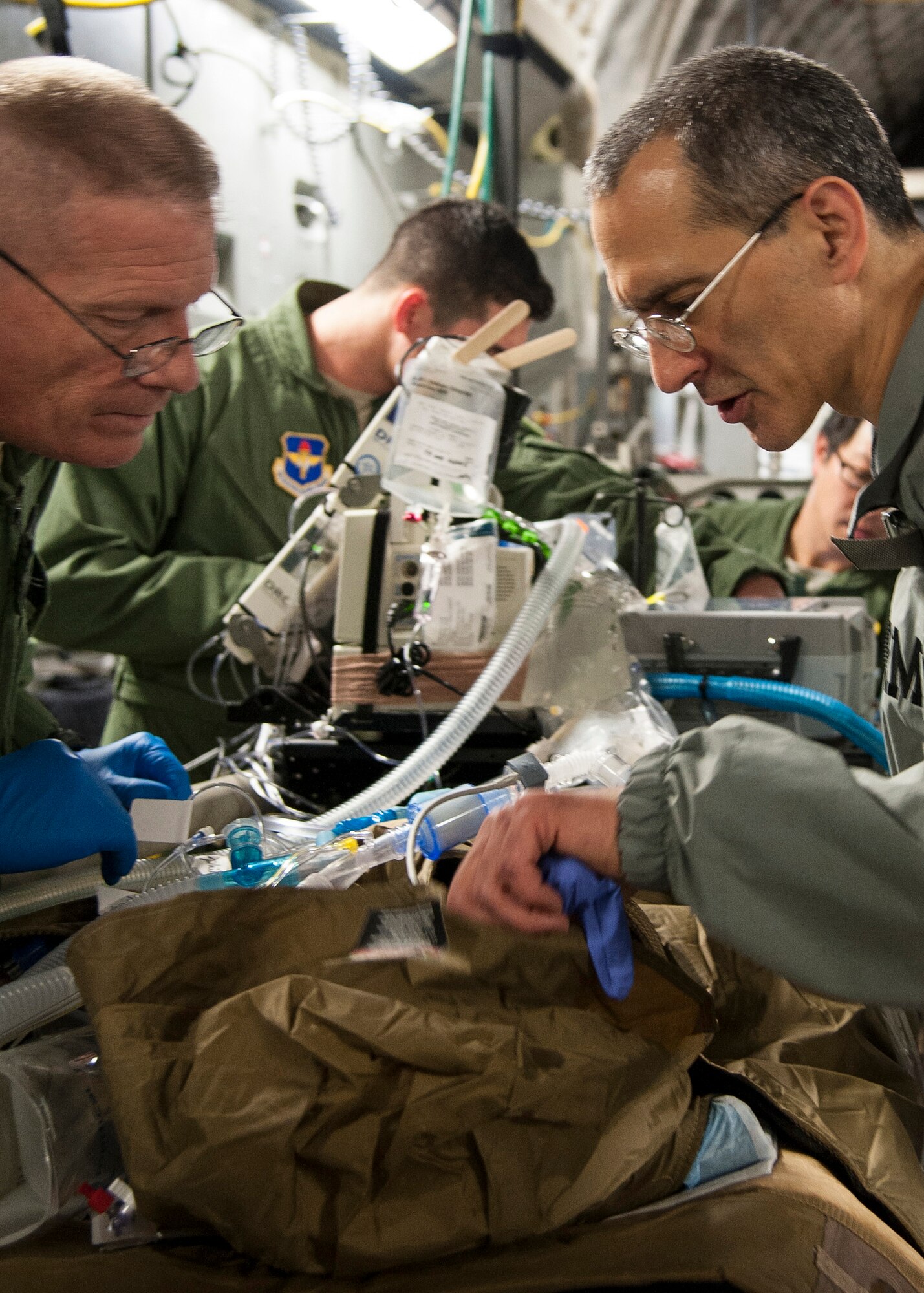 U.S. Air Force Lt. Col. Jeremy Cannon (right) and Army Capt. Michael Campbell both treat an extracorporeal membrane oxygenation patient on a C-17 Globemaster III, Jan. 16, Joint Base San Antonio-Lackland, Texas. (U.S. Air Force photo/Staff Sgt. Kevin Iinuma)