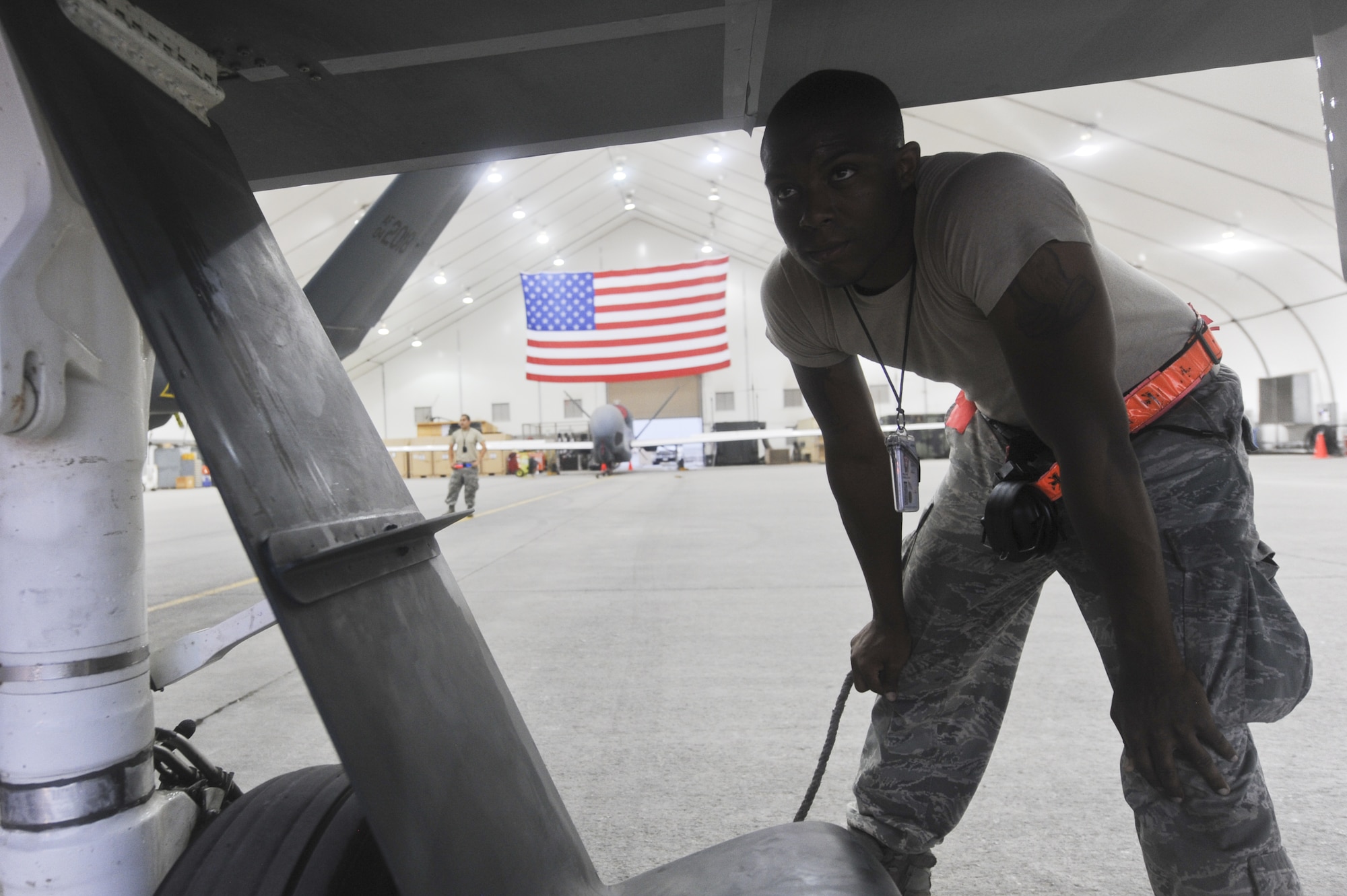 U.S. Air Force Airman 1st Class Donell Williams, 380th Expeditionary Aircraft Maintenance Squadron RQ-4 Global Hawk avionic systems journeyman, waits for the signal to move a Global Hawk forward in a hangar at an undisclosed location in Southwest Asia July 17, 2013. The Global Hawk’s mission here is to provide intellegence, surveillance, reconaissance and communications capabilities over Southwest Asia. Williams calls Compton, Calif., home and is deployed from Beale Air Force Base, Calif.  (U.S. Air Force photo by Senior Airman Jacob Morgan)