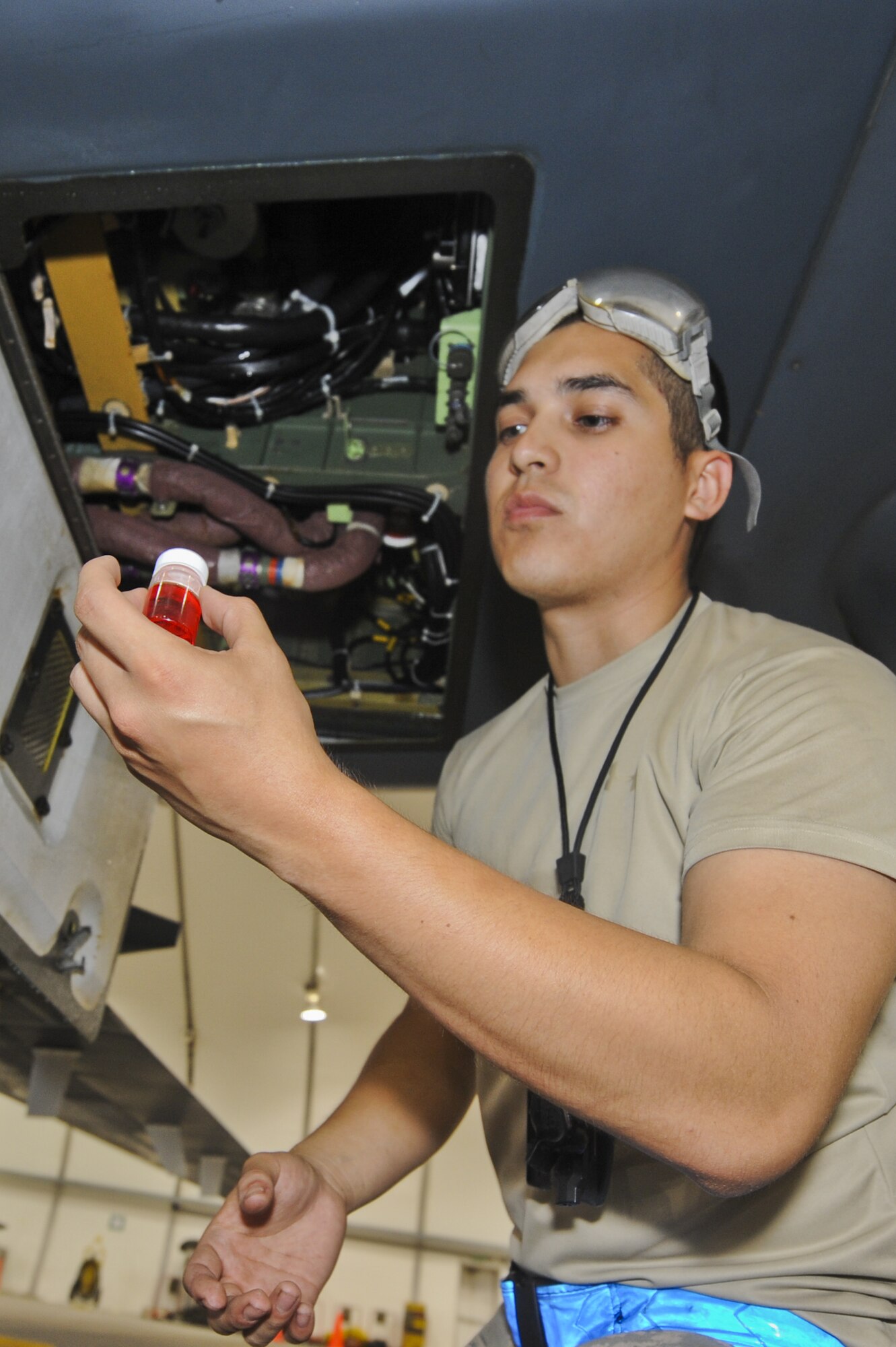 U.S. Air Force Airman 1st Class Jose Cadena, 380th Expeditionary Aircraft Maintenance Squadron RQ-4 Global Hawk crew chief, checks the amount of hydraulic fluid runoff from a Global Hawk in a hangar at an undisclosed location in Southwest Asia July 17, 2013. The Global Hawk’s mission here is to provide intellegence, surveillance, reconaissance and communications capabilities over Southwest Asia. Cadena calls McAllen, Texas, home and is deployed from Grand Forks Air Force Base, N.D. (U.S. Air Force photo by Senior Airman Jacob Morgan)