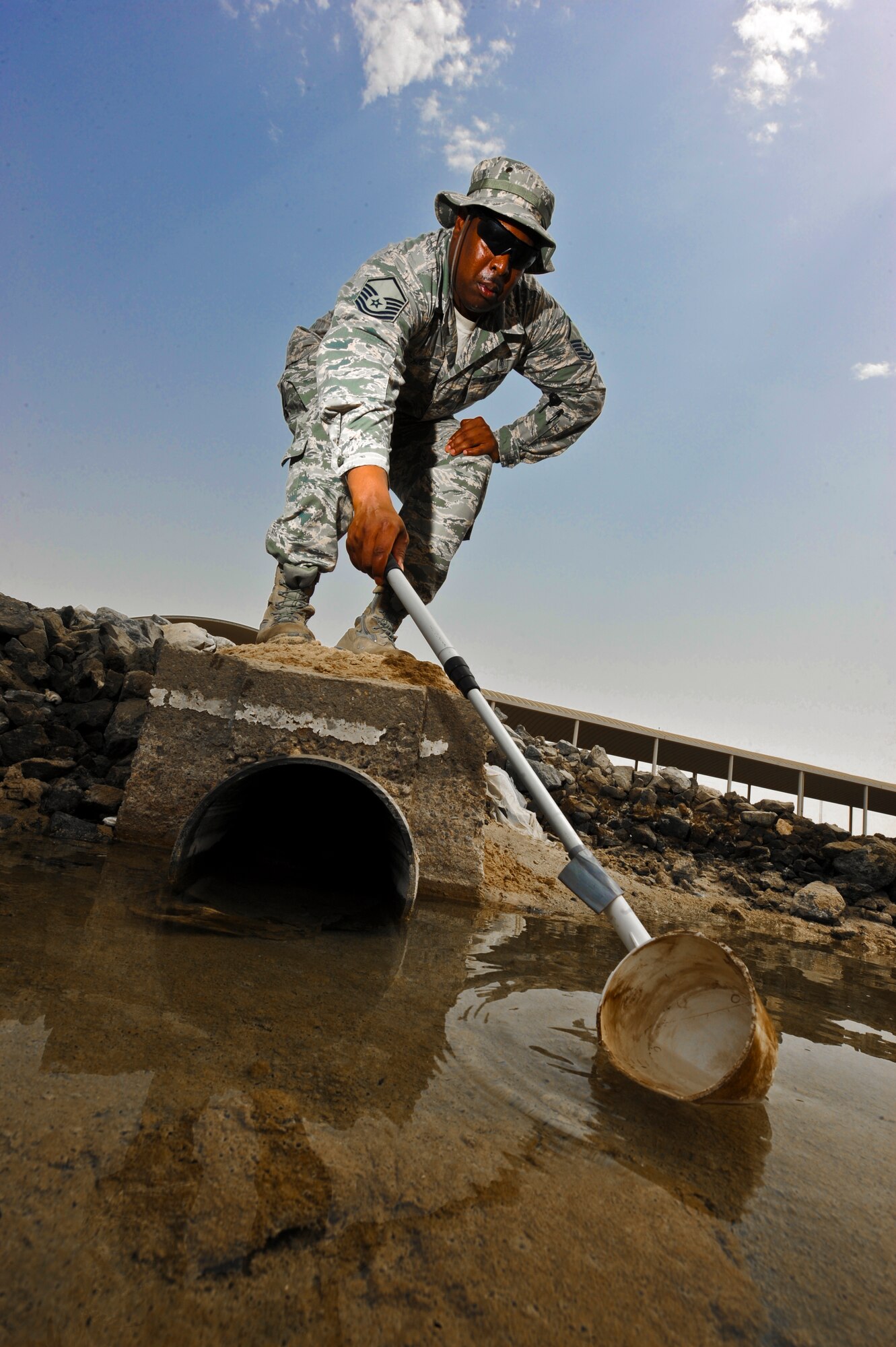U.S. Air Force Master Sgt. Nathan Hanzy, 380th Expeditionary Medical Group NCO in charge of preventive medicine, takes a water sample from a water hole at an undisclosed location in Southwest Asia July 16, 2013. The water is tested for mosquito larva, if larva are present Hanzy will work with entomology to kill off the larva before they spawn. Hanzy is native to Gray, La., and is deployed from Offutt Air Force Base, Neb. (U.S. Air Force photo by Staff Sgt. Joshua J. Garcia)