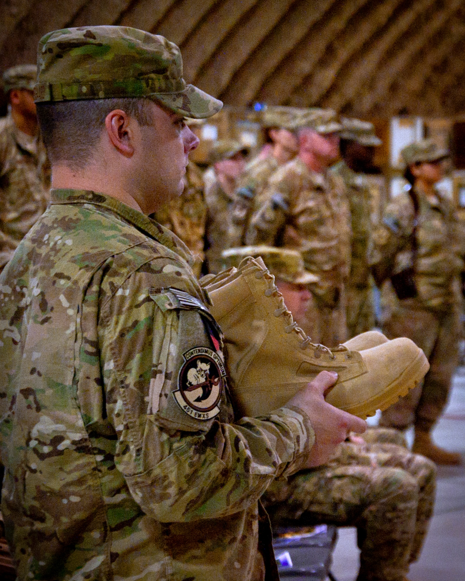 Senior Airman Ian Sondergaard, 451st Expeditionary Maintenance Squadron, carries boots to begin constructing a fallen comrade statue during the Fallen Heroes Memorial Ceremony here July 12. Airmen from the 451st Air Expeditionary Wing gathered together to honor the Airmen of the wing who paid the ultimate sacrifice, and see the unveiling of a new memorial dedicated to the Airmen. (U.S. Air Force photo/Senior Airman Scott Saldukas)