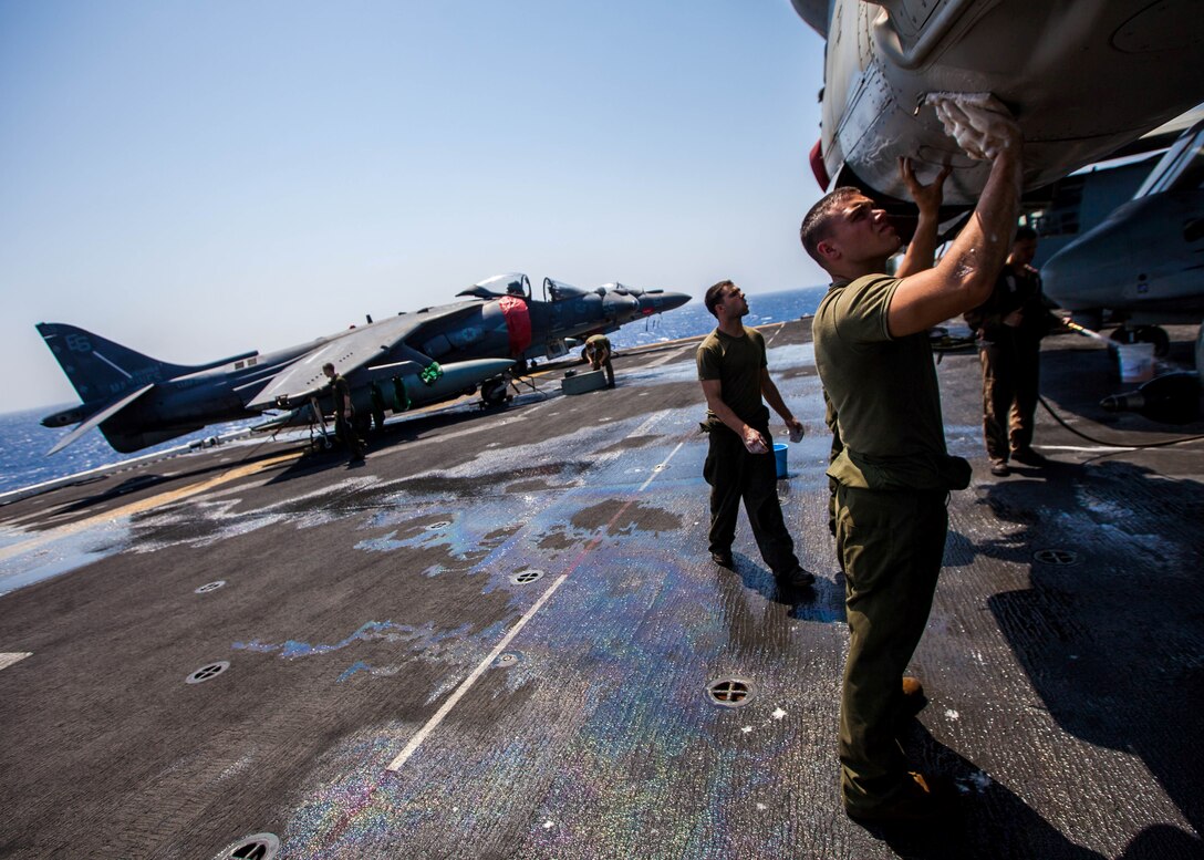 U.S. Marine Corps MV-22B Osprey crew chiefs and mechanics assigned to Marine Medium Tiltrotor Squadron (VMM) 266 (Reinforced), 26th Marine Expeditionary Unit (MEU), wash their aircraft on the flight deck of the USS Kearsarge (LHD 3), at sea, July 20, 2013. The 26th MEU is a Marine Air-Ground Task Force forward-deployed to the U.S. 5th Fleet area of responsibility aboard the Kearsarge Amphibious Ready Group serving as a sea-based, expeditionary crisis response force capable of conducting amphibious operations across the full range of military operations. (U.S. Marine Corps photo by Sgt. Christopher Q. Stone, 26th MEU Combat Camera/Released)