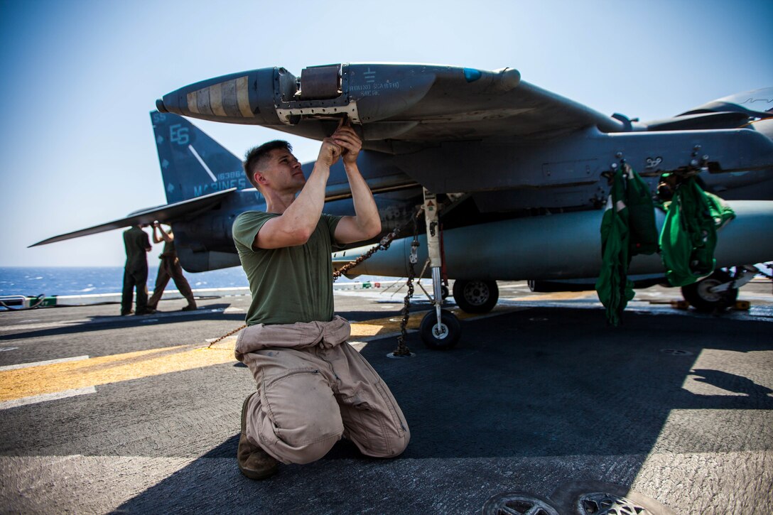 U.S. Marine Corps Sgt. Johnathan Davis, native of Mattoon, Ill., an AV-8B Harrier airframe mechanic assigned to Marine Medium Tiltrotor Squadron (VMM) 266 (Reinforced), 26th Marine Expeditionary Unit (MEU), performs general maintenance on his aircraft on the flight deck of the USS Kearsarge (LHD 3), at sea, July 20, 2013. The 26th MEU is a Marine Air-Ground Task Force forward-deployed to the U.S. 5th Fleet area of responsibility aboard the Kearsarge Amphibious Ready Group serving as a sea-based, expeditionary crisis response force capable of conducting amphibious operations across the full range of military operations. (U.S. Marine Corps photo by Sgt. Christopher Q. Stone, 26th MEU Combat Camera/Released)