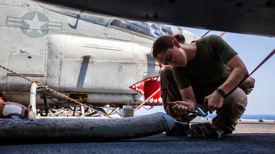 U.S. Marine Corps Cpl. Celia Trout a UH-1N Huey crew chief assigned to Marine Medium Tiltrotor Squadron (VMM) 266 (Reinforced), 26th Marine Expeditionary Unit (MEU), performs corrosion control on n AH-1W Super Cobra on the flight deck of the USS Kearsarge (LHD 3), at sea, July 20, 2013. The 26th MEU is a Marine Air-Ground Task Force forward-deployed to the U.S. 5th Fleet area of responsibility aboard the Kearsarge Amphibious Ready Group serving as a sea-based, expeditionary crisis response force capable of conducting amphibious operations across the full range of military operations. (U.S. Marine Corps photo by Sgt. Christopher Q. Stone, 26th MEU Combat Camera/Released)