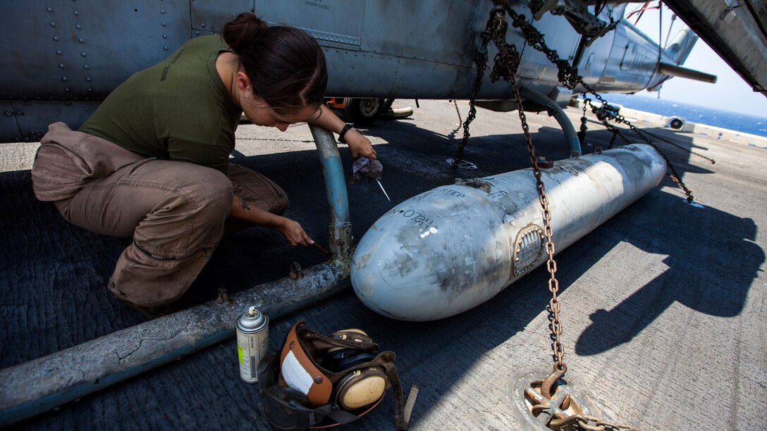 U.S. Marine Corps Cpl. Celia Trout a UH-1N Huey crew chief assigned to Marine Medium Tiltrotor Squadron (VMM) 266 (Reinforced), 26th Marine Expeditionary Unit (MEU), performs corrosion control on n AH-1W Super Cobra on the flight deck of the USS Kearsarge (LHD 3), at sea, July 20, 2013. The 26th MEU is a Marine Air-Ground Task Force forward-deployed to the U.S. 5th Fleet area of responsibility aboard the Kearsarge Amphibious Ready Group serving as a sea-based, expeditionary crisis response force capable of conducting amphibious operations across the full range of military operations. (U.S. Marine Corps photo by Sgt. Christopher Q. Stone, 26th MEU Combat Camera/Released)
