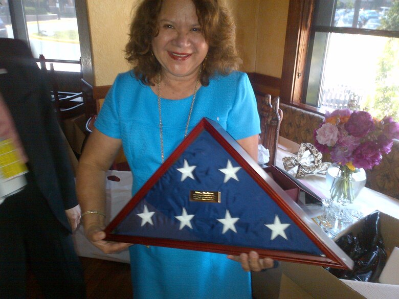 Lillian Almodovar receives flag flown over IWR complex at a ceremony celebrating her retirement.