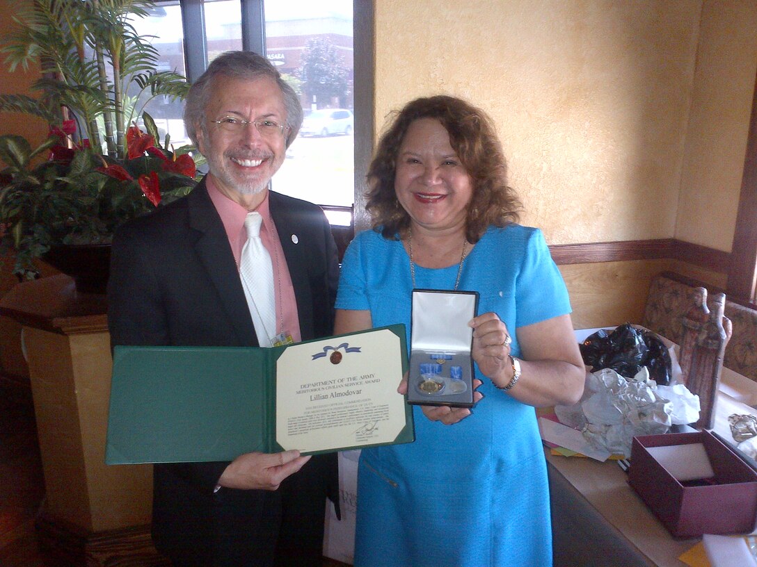 Lillian Almodovar receives certificate  service pin from IWR Director Bob Pietrowsky at a ceremony celebrating her retirement.
