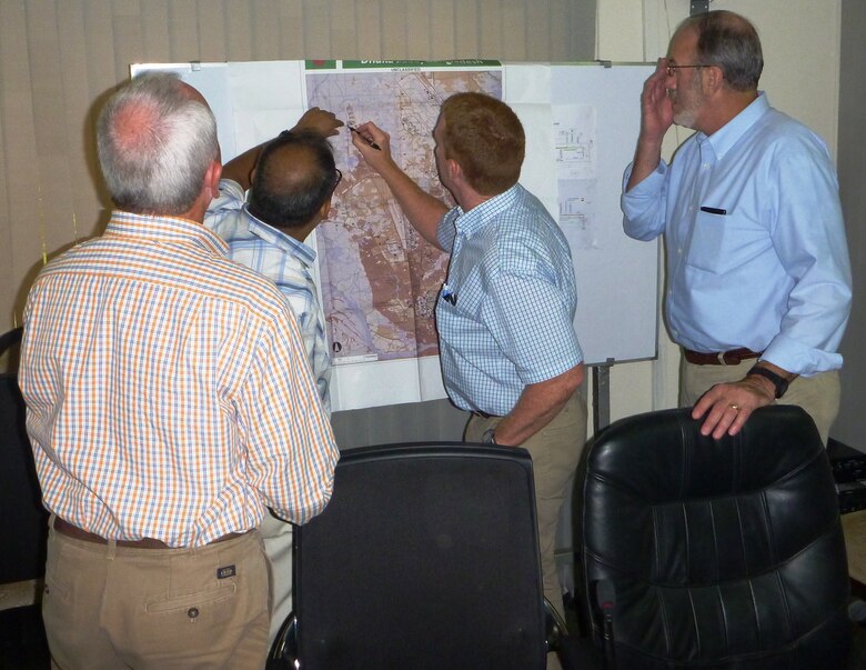U.S. Army Corps of Engineers debris subject matter experts identify potential temporary sorting sites on a map with a Dhaka City Corporation engineer