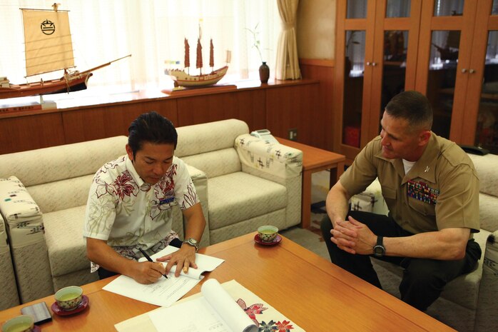 Tetsugi Matsumoto, left, and Col. Edmund J. Bowen sign a limited humanitarian access agreement July 12 at Urasoe City Hall. The agreement is designed to save lives by giving Okinawa emergency personnel vehicular entry to the Makiminato service area of Camp Kinser. Matsumoto is the mayor of Urasoe City, and Bowen is the Camp Kinser commander and commanding officer of Combat Logistics Regiment 37, 3rd Marine Logistics Group, III Marine Expeditionary Force.