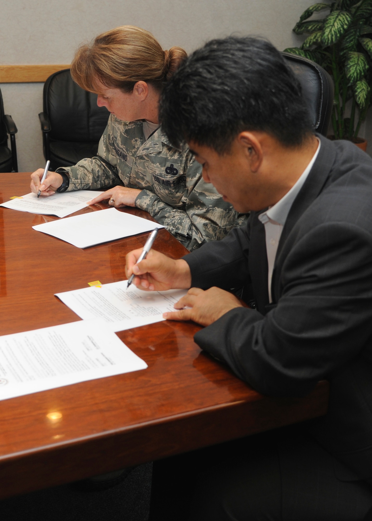 Colonel Carrie Bausano, 8th Mission Support Group commander, and Mr. Kim Young Il, Republic of Korea air force Operation Center representative, sign an agreed recommendation to allow joint use of real estate on Kunsan Air Base, ROK, July 11, 2013. The cooperation between ROKAF and United States Forces Korea on this project will increase their air defense capability, as directed by 7th Air Force. (U.S. Air Force photo by Senior Airman Jessica Haas/released)
