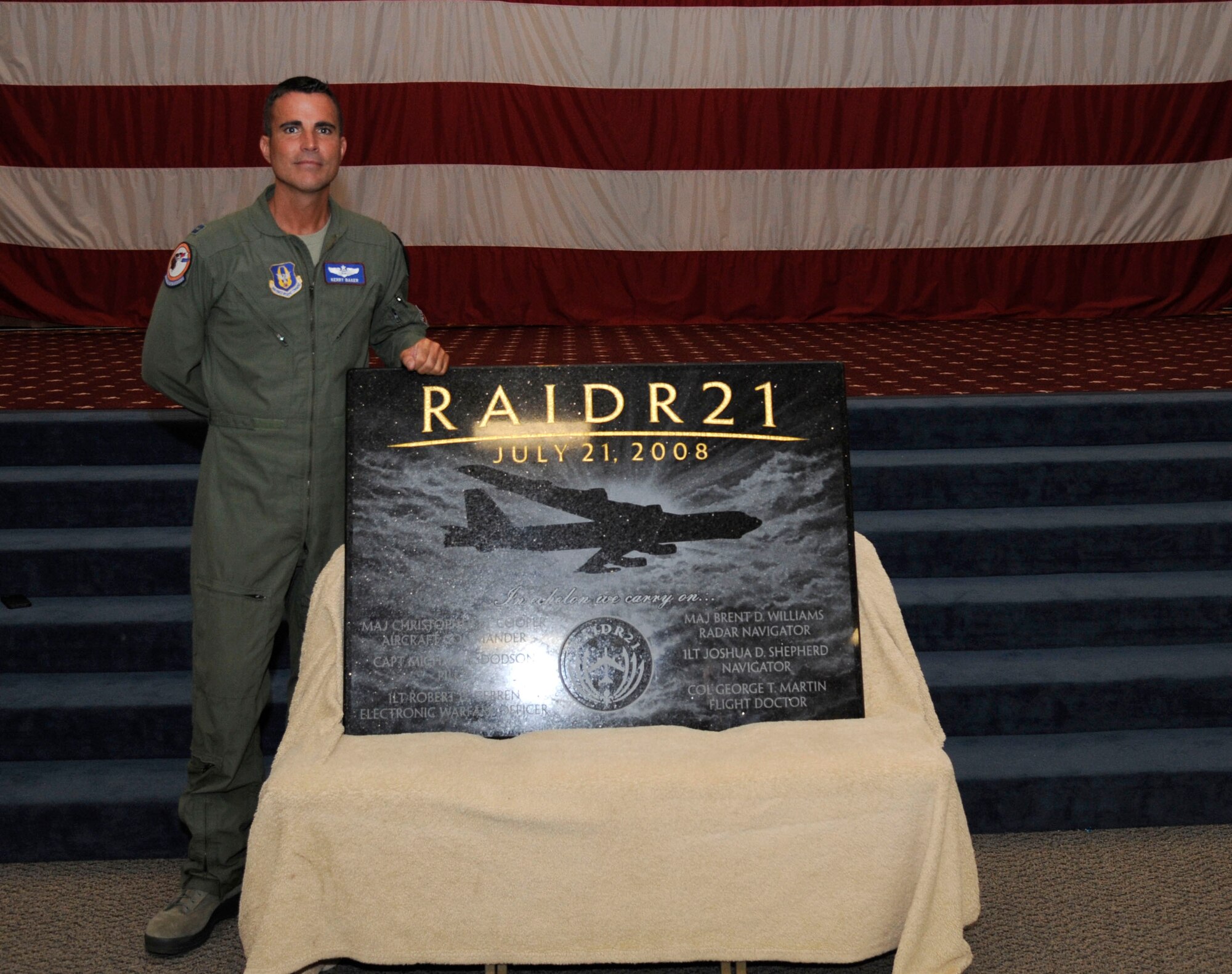 Capt. Kerry Baker, 93rd Bomb Squadron radar navigator, stands with a plaque he created to honor the crew of RAIDR 21 on Barksdale Air Force Base, La., July 21, 2013. The plaque was unveiled to family and friends during a remembrance ceremony. (U.S. Air Force photo/Airman 1st Class Andrew Moua)