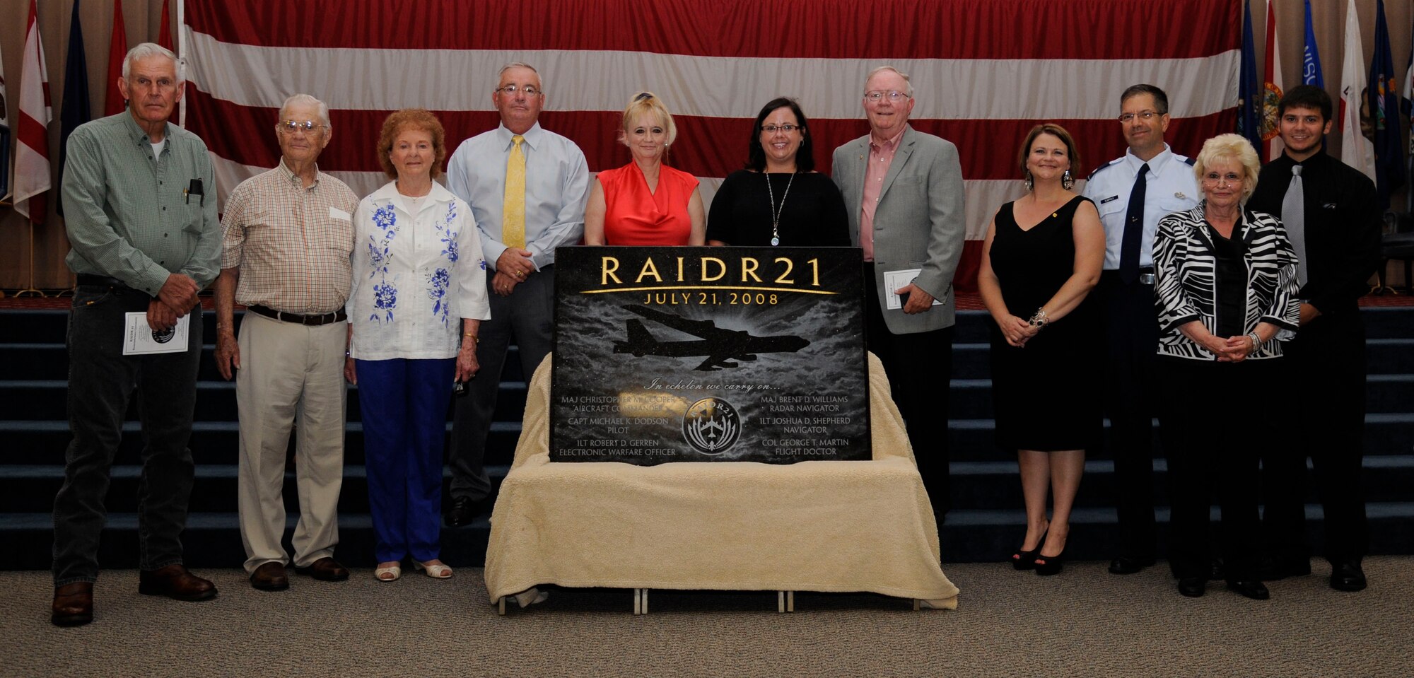 Family members of the RAIDR 21 crew stand behind a plaque created in memory of their loved ones during a remembrance ceremony on Barksdale Air Force Base, La., July 21, 2013. The plaque lists the names of the crew: Col. George Martin, Maj. Christopher Cooper, Maj. Brent Williams, Capt. Michael Dodson, and First Lieutenants Robert Gerren and Joshua Sheperd. (U.S. Air Force photo/Airman 1st Class Andrew Moua)