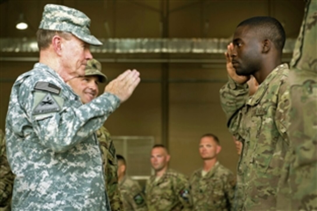 U.S. Army Gen. Martin E. Dempsey, chairman of the Joint Chiefs of Staff, returns the salute from an airman first class during a visit to Afghanistan, July 21, 2013. The airman is assigned to the support air refueling mission at Mazar-i-Sharif.