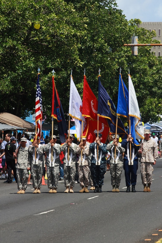 Guam native Sergeant Albert Opena III (carrying the Marine Corps flag in the center) and Texas native Corporal German Trevizo (far right) participate in the joint color guard as they march down Marine Corps Drive during the Liberation Day Parade July 21 on Guam. The annual parade concludes a series of memorials and celebrations around the island to honor local Chamorros and Marines who died at Japanese hands in the 1941 invasion and occupation and 1944 liberation of the island and celebrate the freedom of Guam.  Local villages and organizations hosted the Guam Marines on various floats in the parade in appreciation for the Marines who liberated the island from Japanese occupation in 1944.    (Official U.S. Marine Corps photo by Sgt. John Raufmann)  