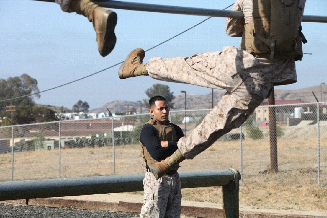Sergeant Jose A. Tellez, chief martial arts instructor, 7th Engineer Support Battalion, 1st Marine Logistics Group, supervises Marines conducting the obstacle course during the Marine Corps Martial Arts Program instructor course aboard Camp Pendleton, Calif., July 16, 2013. The MCMAP instructor course is a physically rigorous, three-week program designed to teach Marines techniques, philosophy, history and structure behind MCMAP.