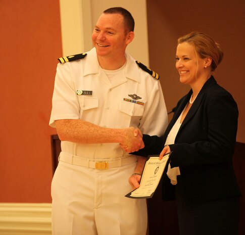 Lt. Kenneth Bull, a graduating intern, receives a certificate from Phyllis MacGilvray, the program director of Naval Hospital Camp Lejeune's Family Residency Program at the program’s graduation ceremony at Marston Pavilion aboard Marine Corps Base Camp Lejeune, June 28. This year’s class is the tenth to graduate. To date, 51 family physicians have been trained at the hospital. 