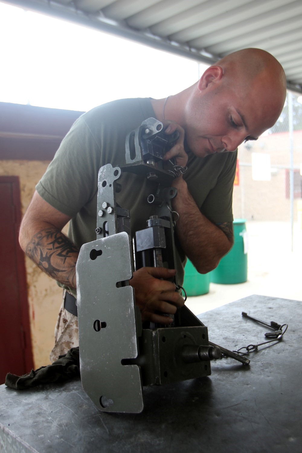 Sergeant Thomas Reed, a training noncommissioned officer serving with Truck Company Alpha, Headquarters Battalion, 1st Marine Division, inspects and cleans a MK93 Heavy Machine Gun Mounting System during the Basic Mk-19 Heavy Machine Gun Course here, June 11, 2013. Throughout the course, support Marines were instructed by experienced machine gunners who are combat veterans. The course tested Marines on the weapon nomenclature, weapon conditions, the weapon's range, different types of ammunition and range cards. Reed, a native of Wooster, Ohio, was sent to the course to prepare himself and his junior Marines for an upcoming combat deployment to Afghanistan.