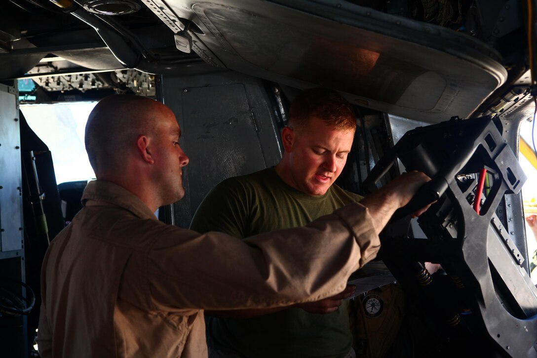 Sgt. Christopher Johnson, right, an aerial gunner instructor with Marine Heavy Helicopter Squadron 465 "Warhorses" and a Youngstown, Ohio, native, goes over information before a training mission with Staff Sgt. Franklin Williams, left, an aviation ordnance technician with the Warhorses and a San Diego native, aboard Marine Corps Air Station Miramar, Calif., July 17. Johnson served as one of Williams evaluators for the mission so he could earn his aerial observer's wings.