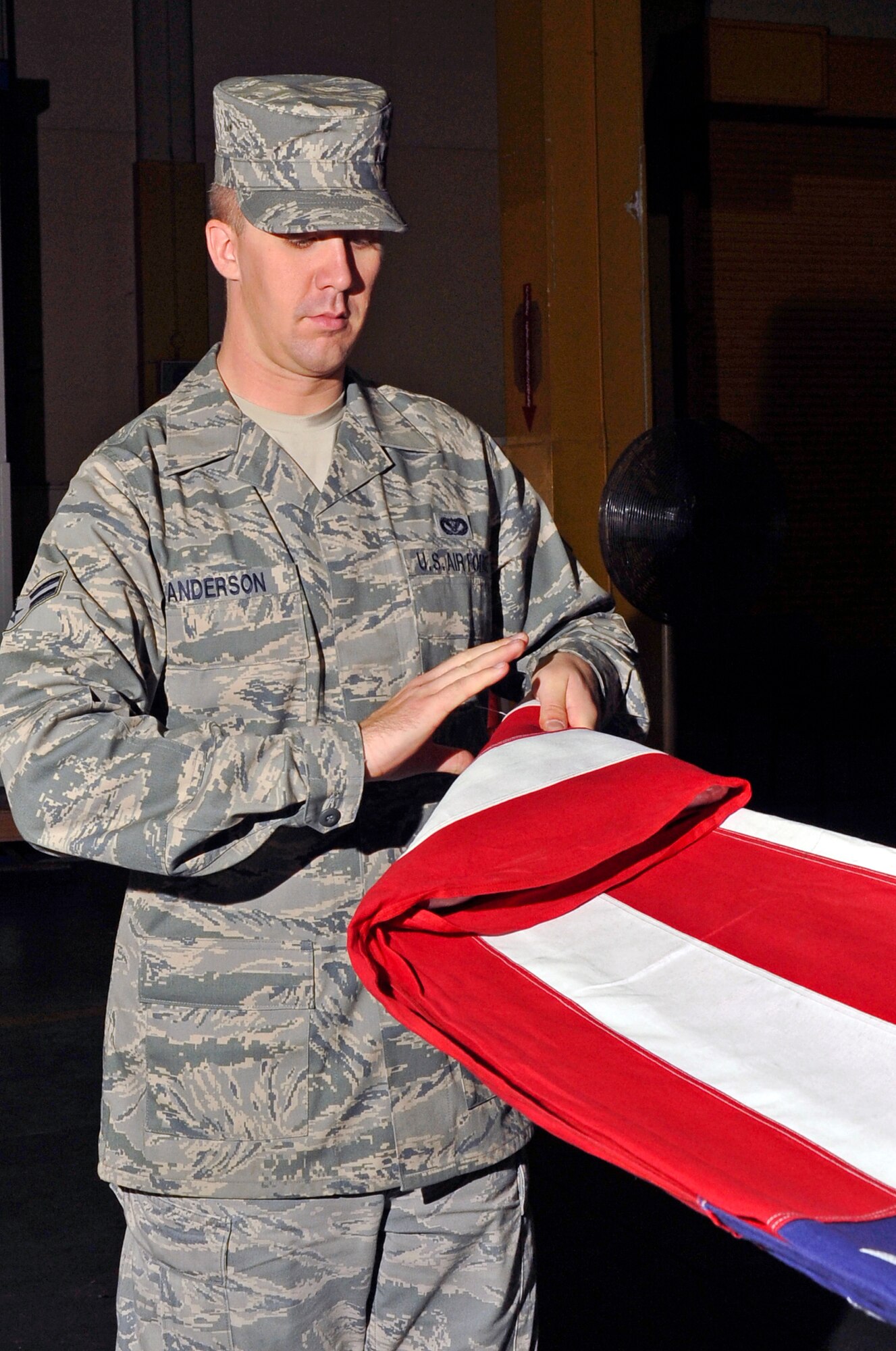 U.S. Air Force Airman 1st Class David Anderson, Misawa Honor Guard trainer, shows members of the Honor Guard the proper way to fold a flag at Misawa Air Base, Japan, July 3, 2013. Guardsmen must know how to fold a flag so they can fold it correctly at retirement ceremonies, retreat ceremonies or at military funeral services. (U.S. Air Force photo by Airman 1st Class Zachary Kee) 