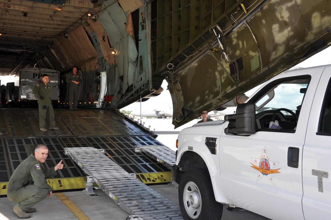 Members of the 149th Fighter Wing Crisis Management Team of the Texas Air National Guard drove their vehicles and trailers loaded with equipment onto a C-5 under the supervision of loadmasters from the 68th Airlift Squadron.  Staff Sgt. Bryan Stone approves a trucks clearance by giving  thumbs up to a Texas Air Guardsmen driving his vehicle onto an 433rd Airlift Wing C-5. (U.S. Air Force Photo by Tech. Sgt. Carlos J. Trevino)
