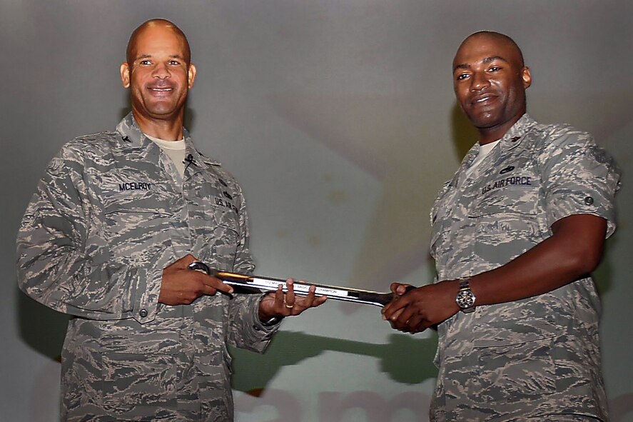 Col. Kelvin D. McElroy, 512th Maintenance Group commander, left, presents an award to Maj. Anthony Linton, 712th Aircraft Maintenance Squadron commander, at Dover Air Force Base, Del., July 14, 2013. Linton accepted the award on behalf of his unit’s maintainers as they won a back-to-basics Challenge at the base theater. (U.S. Air Force photo/Senior Airman Joe Yanik)
