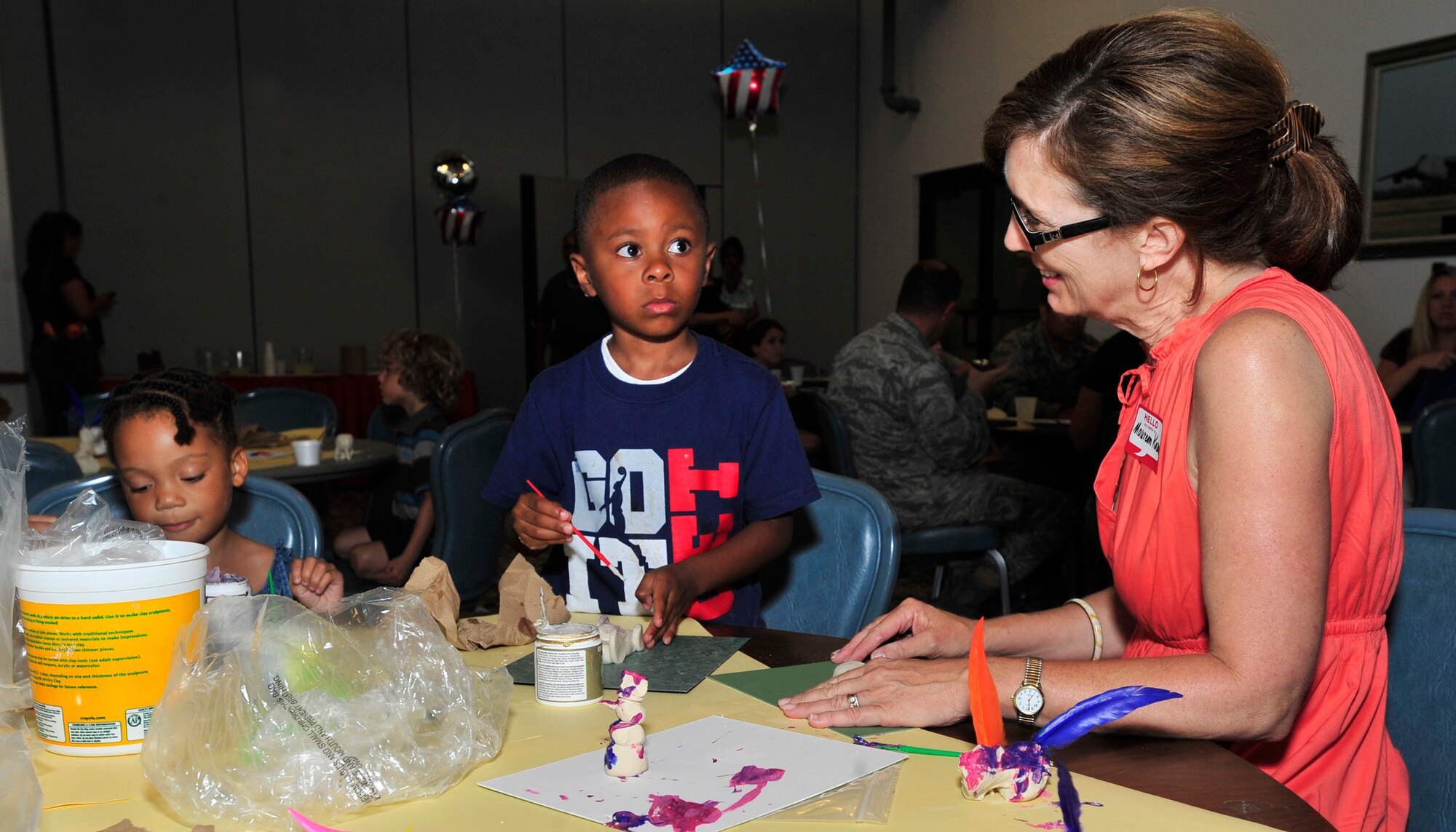 Maureen Kozak, wife of Col. Raymond Kozak, 512th Airlift Wing commander, right, helps Lalah Young and Michael Perkins with crafts at the Deployed Spouses Dinner July 18, 2013, at The Landings on Dover Air Force Base, Del. The dinner allowed spouses and children of deployed Team Dover members the opportunity to enjoy a meal, participate in arts and crafts and get information from base support agencies. (U.S. Air Force photo/Tech. Sgt. Chuck Walker)