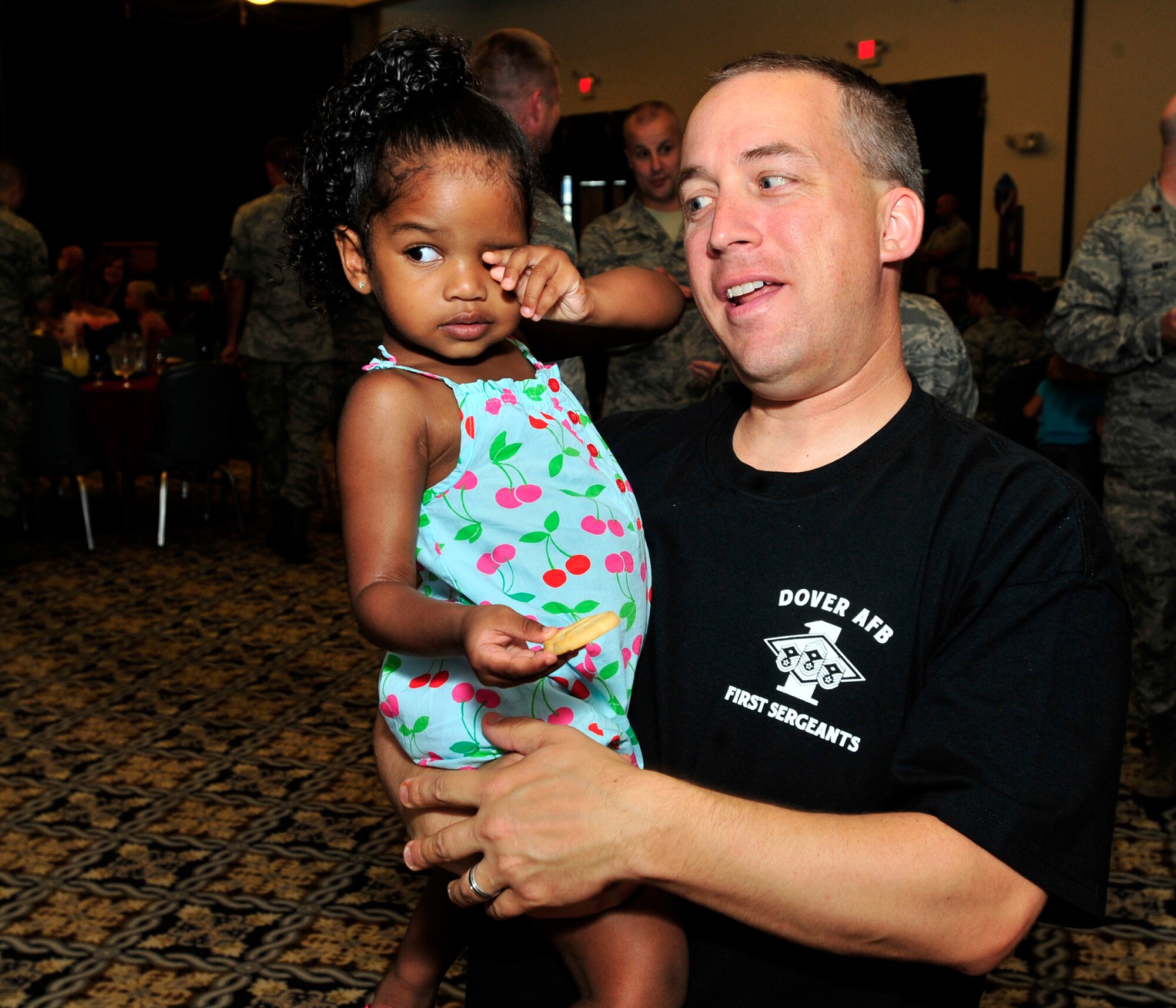 Master Sgt. David Rife, 436th Comptroller Squadron first sergeant, holds Andraya Leonard during the Deployed Spouses Dinner July 18, 2013, at The Landings on Dover Air Force Base, Del. Leonard is the daughter of Tech. Sgt. Andre Leonard, 436th Airlift Wing/Command Post, who is currently deployed. (U.S. Air Force photo/Tech. Sgt. Chuck Walker)