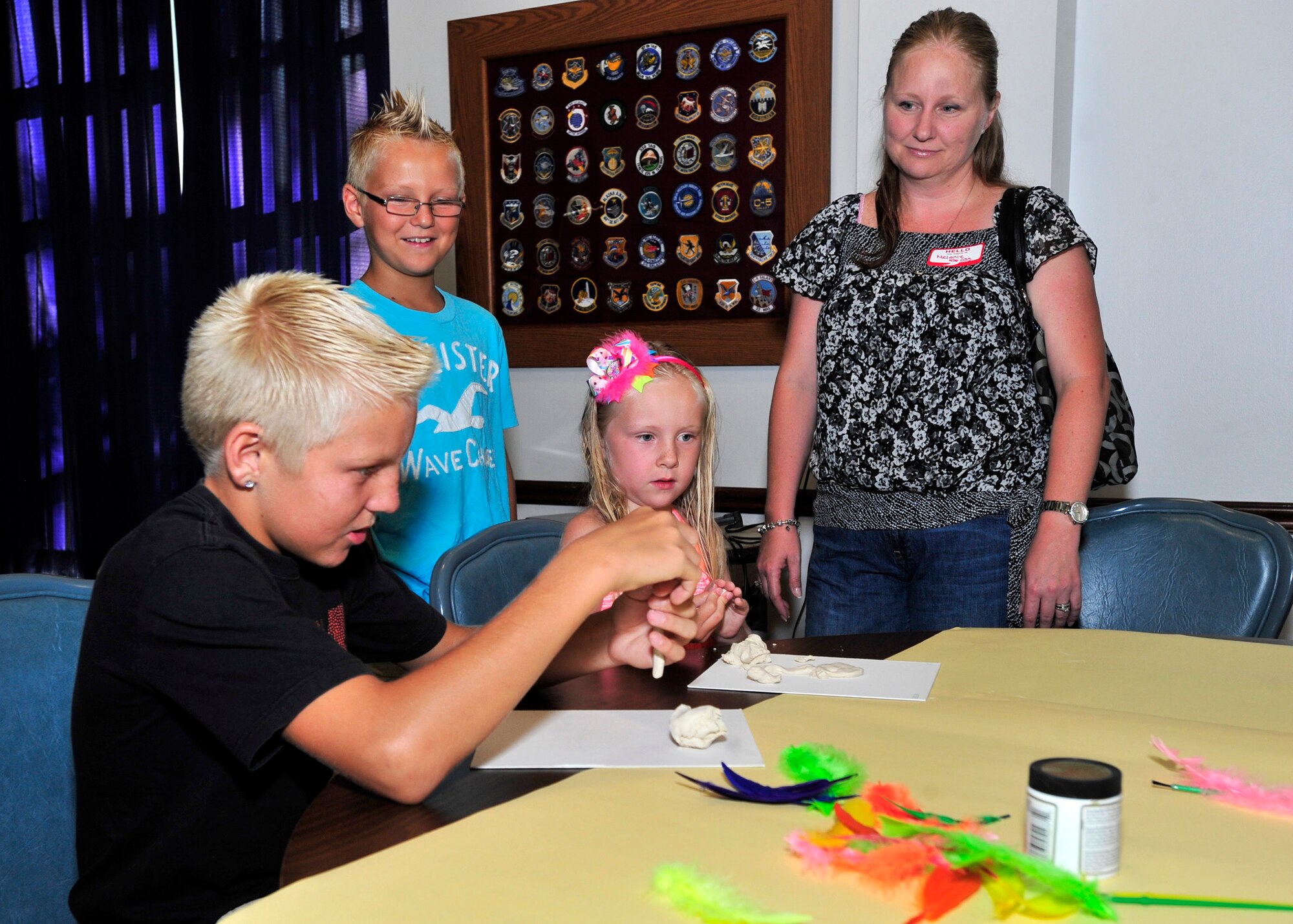 Shane Lawson, front, works on a craft while his brother Justin, sister Kristin and Mom Melanie look on during the Deployed Spouses Dinner July 18, 2013, at The Landings on Dover Air Force Base, Del. The Lawsons participated in the dinner while their husband/father Staff Sgt. Shawn Lawson, 436th Operational Support Squadron is deployed. (U.S. Air Force photo/Tech. Sgt. Chuck Walker)