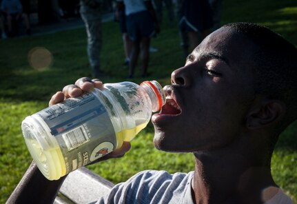 Senior Airman Tajai Elliott, 437th Aircraft Maintenance Squadron crew chief, cools down with a drink after a game of basketball July 19, 2013, at the Dorm Challenge at Joint Base Charleston - Air Base, S.C. The quarterly competition is a Wing initiative intended to encourage resident interaction and camaraderie as part of Comprehensive Airman Fitness.  The Dorm Challenge consisted of push-ups, sit-ups, and games of cornhole and basketball. (U.S. Air Force photo/Senior Airman Ashlee Galloway)