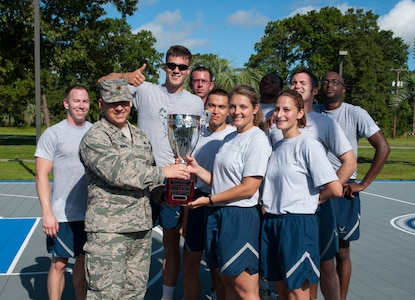 Maj. Joseph Wingo, 628th Communications Squadron commander, presents the Dorm Challenge trophy to Dorm 461, winners of the Dorm Challenge July 19, 2013, at Joint Base Charleston – Air Base, S.C. The quarterly competition is a Wing initiative intended to encourage resident interaction and camaraderie as part of Comprehensive Airman Fitness.  The Dorm Challenge consisted of push-ups, sit-ups, and games of cornhole and basketball. (U.S. Air Force photo/Senior Airman Ashlee Galloway)