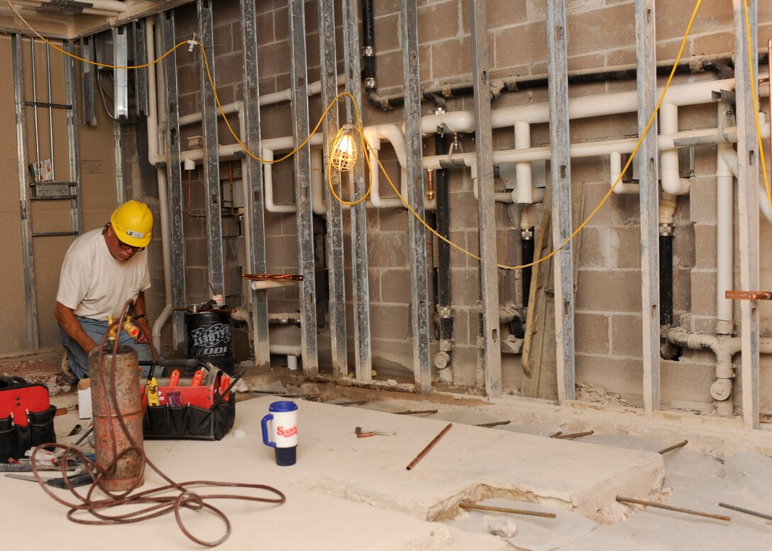 Jim Tyndall, Plumbing Design and Installation Inc. master plumber, installs polyvinyl chloride piping inside the Jefferson Chambers Dormitory kitchenette during a renovation project at Ellsworth Air Force Base, S.D., July 15, 2013. The $360,000 was funded to provide more space for Airmen of the dorms to prepare and cook meals. (U.S. Air Force photo by Airman 1st Class Anania Tekurio/Released)