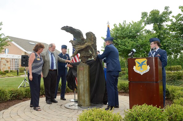 A bronze sculpture named The Angel and the Dying Unknown is unveiled by (L to R) Ms. Karen Mordus, President of Friends of the Fallen, Mr. Greg Wyatt, sculptor, Col. John Devillier, Air Force Mortuary Affairs Operations commander and Col. Rick Moore, 436th Airlift Wing commander in the meditation garden near the Fisher House on July 22, 2013 at Dover Air Force Base, Del. The sculpture was donated by the Newington-Cropsey Foundation, an organization that focuses on preserving and displaying art.  (U.S. Air Force photo/Greg L. Davis)