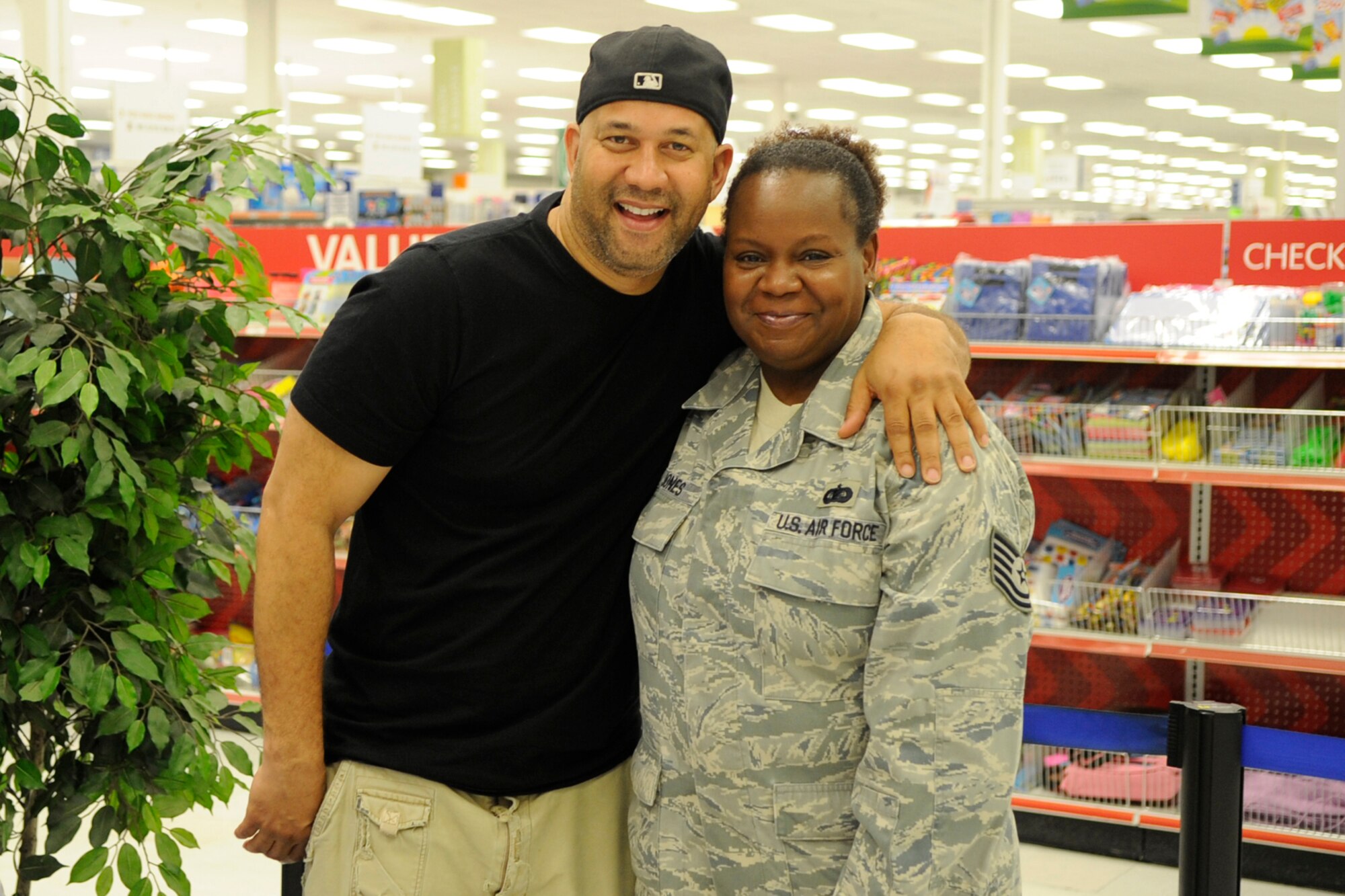 Tech. Sgt. Linda Jones, who is an information management clerk assigned to the 307th Bomb Wing, poses for a photo with Pierre after getting his autograph during a meet and greet session at the Barksdale Exchange on Barksdale Air Force Base, La., July 19, 2013. Pierre visited with the troops and took a tour of a B-52 Stratofortress before performing his comedy routine later that night at the Stripes Club on base. (U.S. Air Force photo by Master Sgt. Jeff Walston/Released)