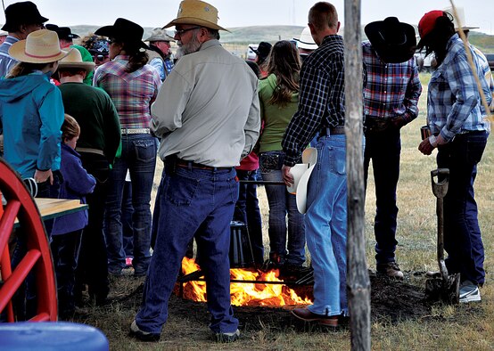 A crowd of people gather around the fire to stay warm July 14, 2013, near the Iron Mountain and Yellowstone Roads, Cheyenne, Wyo., prior to the 2013 Cheyenne Frontier Days Cattle Drive. (U.S. Air Force photo by Senior Airman Mike Tryon)