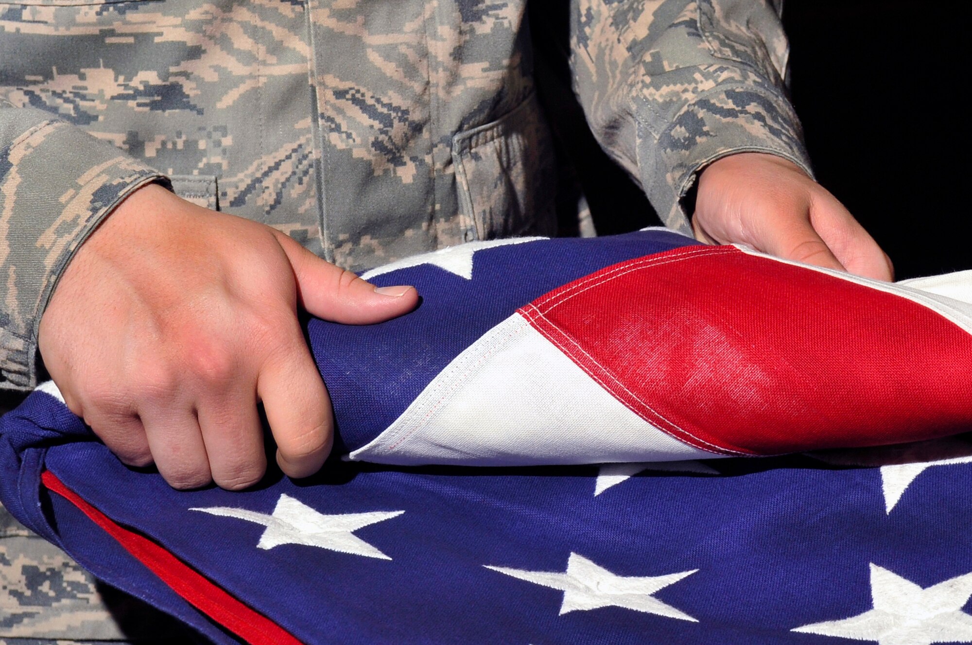 U.S. Air Force Airman 1st Class Christopher Harrell, Misawa Honor Guard guardsmen, folds a flag during Honor Guard practice at Misawa Air Base, Japan, July 3, 2013. To become a member of the Misawa Honor Guard, Guardsmen are put through an eight-week training program that teaches them the basic movements, services and ceremonies performed in the Honor Guard. (U.S. Air Force photo by Airman 1st Class Zachary Kee)