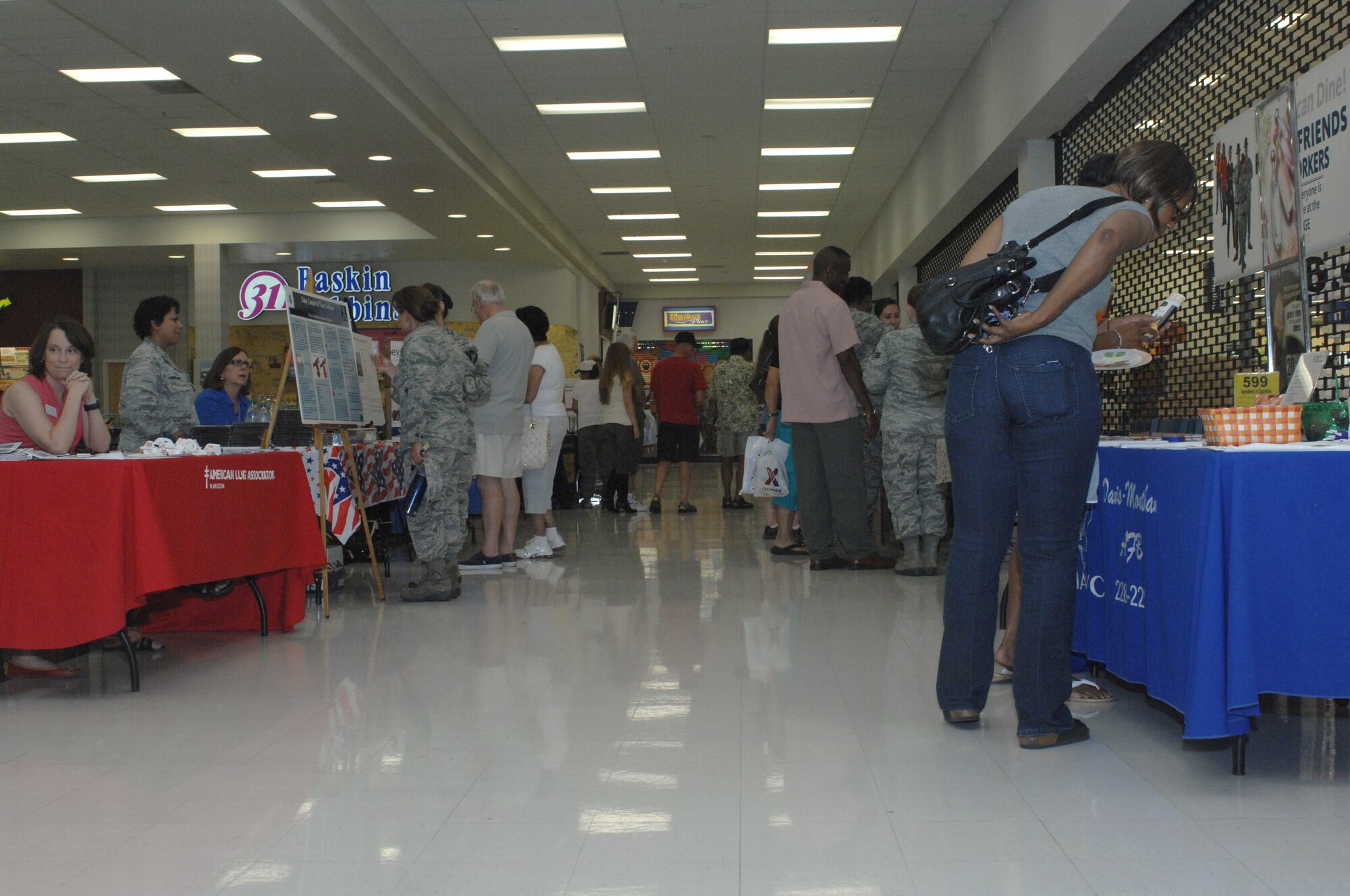 Members of the Desert Lightning Team visit booths at the Family Health and Fitness Fair at Davis-Monthan Air Force Base, Ariz., July 19, 2013. Guests got a chance to talk and ask questions of base agencies about information and services available to them. (U.S. Air Force photo by Airman 1st Class Betty R. Chevalier/Released)