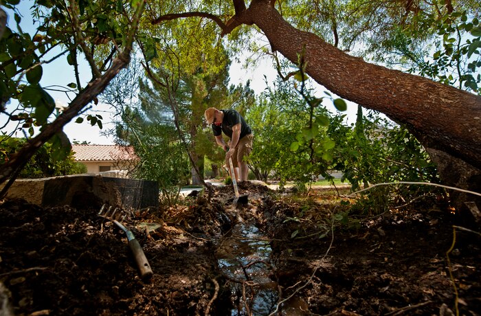 U.S. Air Force Staff Sgt. Earl Tilton, 57th Aircraft Maintenance Squadron electronics and environmental technician, pulls water out of a ditch made to expose a sprinkler July 19, 2013, at St. Jude’s Ranch for Children in Boulder City, Nev.  Members of the 57th AMXS volunteered by fixing sprinklers, organizing the gift shop, cleaning up the grounds, cooking lunch and spending the afternoon playing water activities with the children. (U.S. Air Force photo by Senior Airman Daniel Hughes)
