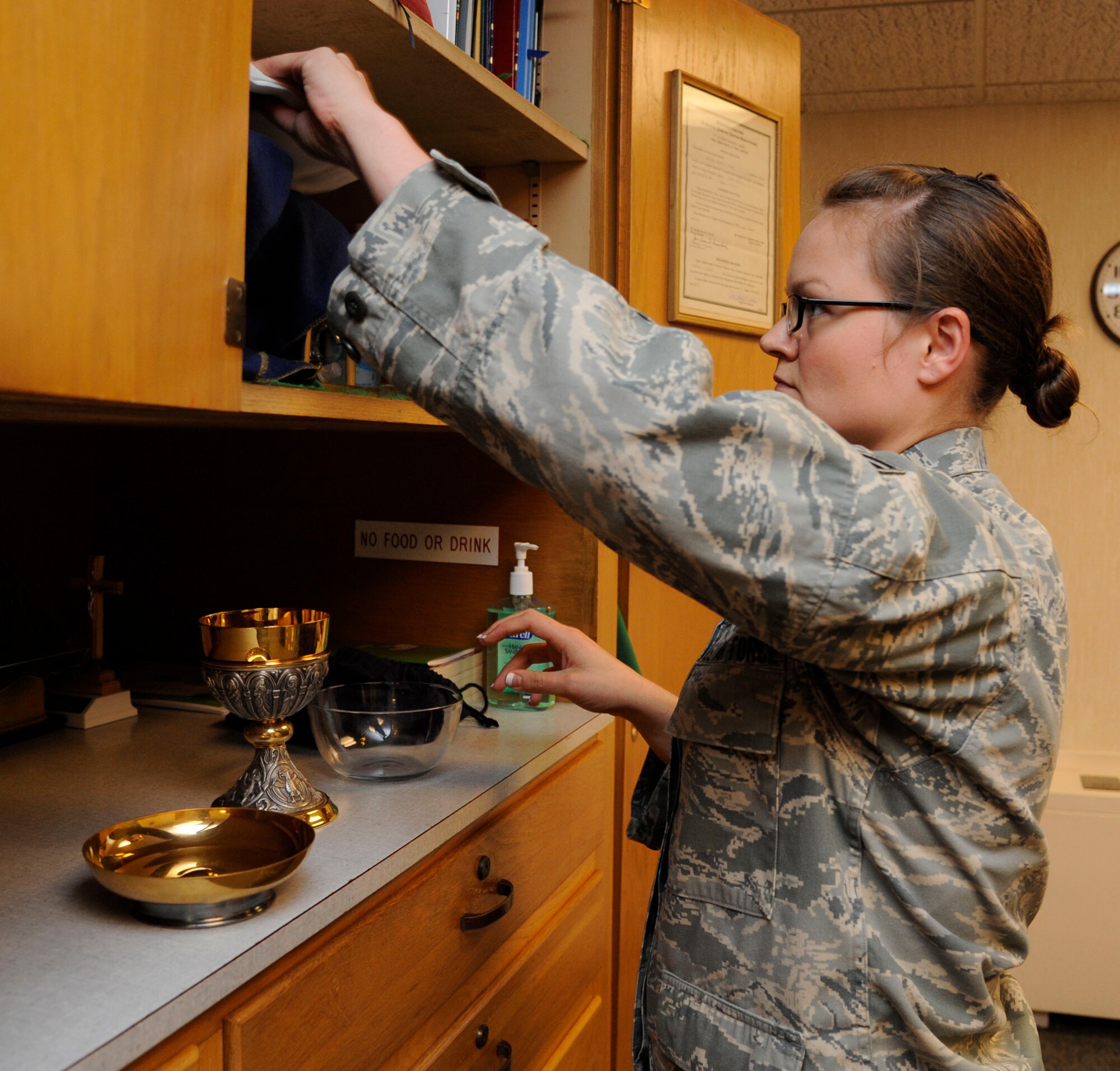 Senior Airman Alisha Smith, 2nd Bomb Wing Chaplain's Assistant, gathers material for mass at Chapel 2 on Barksdale Air Force Base, La., July 22, 2013. The items include wine, bread and a goblet for communion. (U.S. Air Force photo/Airman 1st Class Andrew Moua)