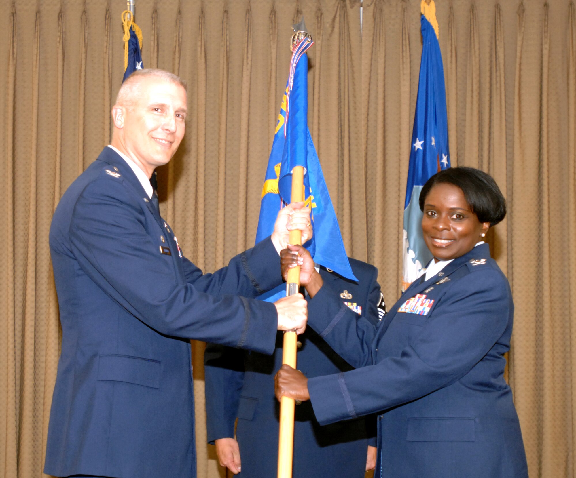 Col. Terri Bailey accepts the 319th Medical Group’s guidon from Col. Paul Bauman, 319th Air Base Wing commander, during a change-of-command ceremony July 19, 2013, on Grand Forks Air Force Base, N.D. Bailey replaced the outgoing 319th MDG commander, Col. Jane Denton. (U.S. Air Force photo/Staff Sgt. Susan L. Davis)