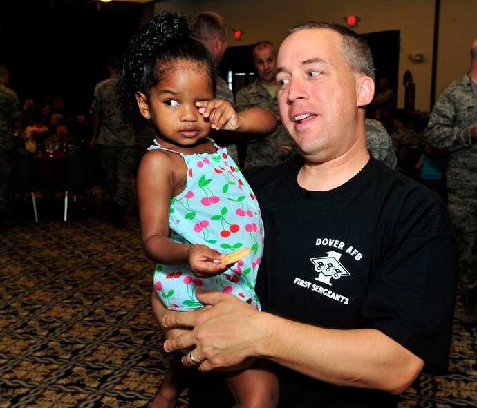 Master Sgt. David Rife, 436th Comptroller Squadron first sergeant, holds Andraya Leonard during the Deployed Spouses Dinner July 18, 2013, at The Landings on Dover Air Force Base, Del. Leonard is the daughter of Tech. Sgt. Andre Leonard, 436th Airlift Wing/Command Post, who is currently deployed. (U.S. Air Force photo/Tech. Sgt. Chuck Walker)