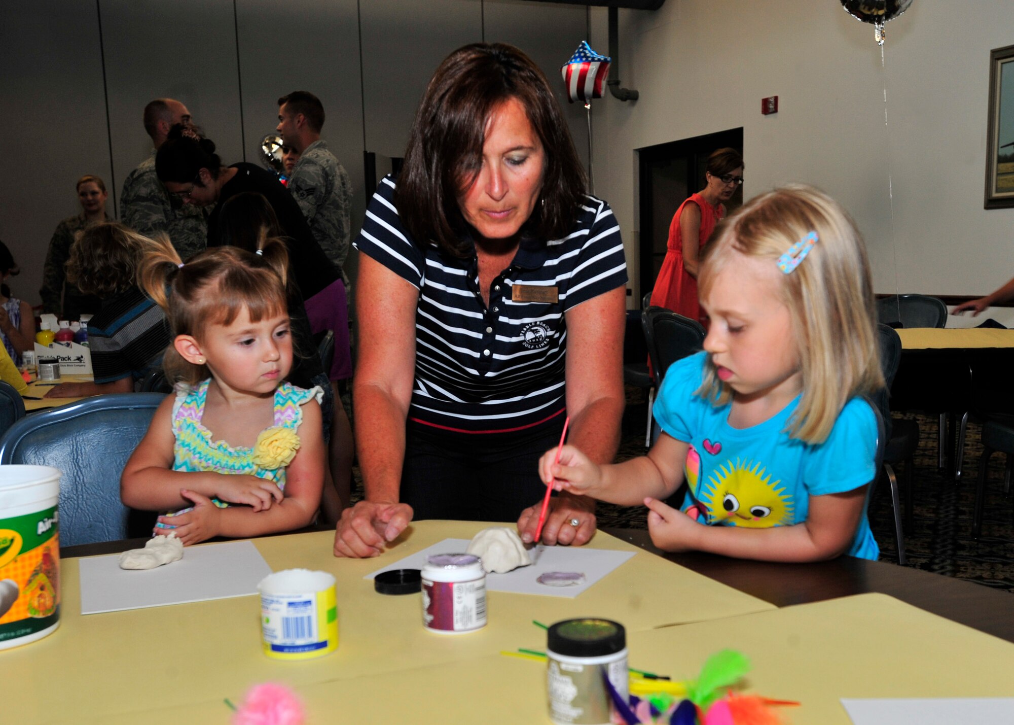 Troi Reppart, wife of Col. Thomas Reppart, 436th Mission Support Group commander, helps Payton Hawkins, left, and Olivia Hawkins with a craft July 18, 2013, at The Landings on Dover Air Force Base, Del. Team Dover hosted a Deployed Spouses Dinner that allowed spouses and children of deployed members the opportunity to enjoy a meal, play games and receive information from base support agencies. (U.S. Air Force photo/Tech. Sgt. Chuck Walker)