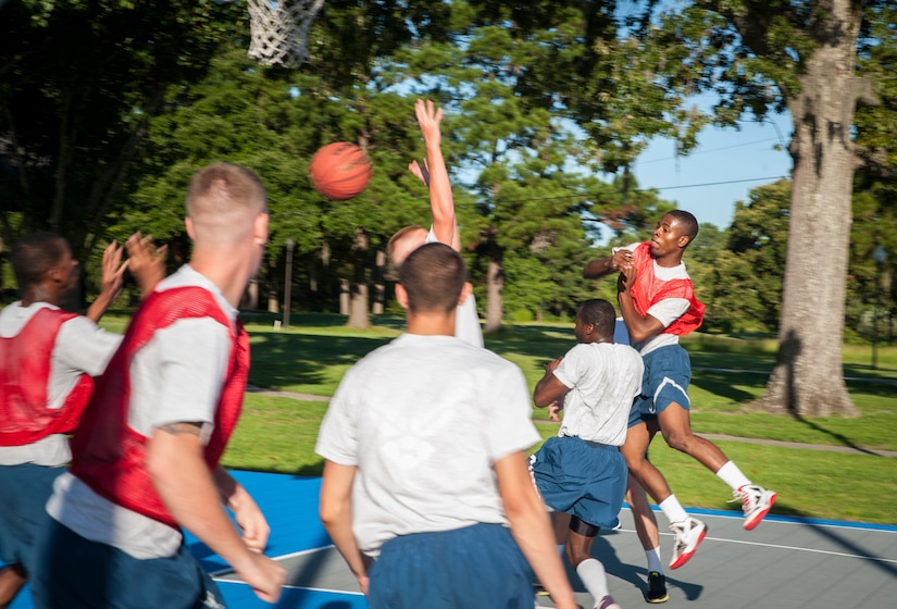 Senior Airman Tajai Elliott, 437th Aircraft Maintenance Squadron crew chief, passes the ball to Airman 1st Class Charles Cannon, 437th Maintenance Squadron Aerospace Ground Equipment journeyman, during a basketball game July 19, 2013, at the Dorm Challenge at Joint Base Charleston - Air Base, S.C. The quarterly competition is a Wing initiative intended to encourage resident interaction and camaraderie as part of Comprehensive Airman Fitness. The Dorm Challenge consisted of push-ups, sit-ups, and games of cornhole and basketball. (U.S. Air Force photo/Senior Airman Ashlee Galloway)