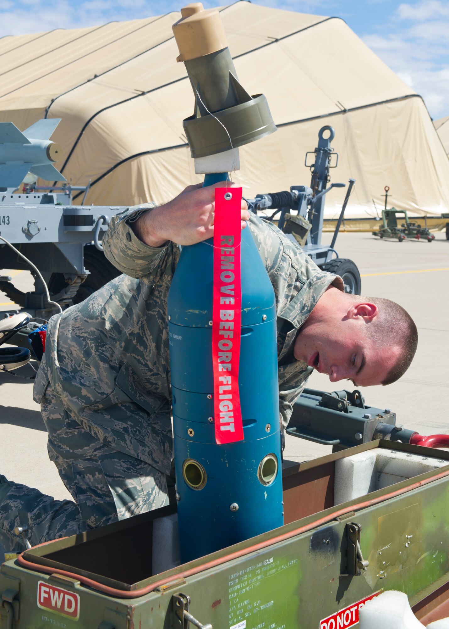 Airman 1st Class Christopher Ryan, 849th Aircraft Maintenance Squadron weapons load crew member, lifts an inert bomb out of its protective case in preparation for loading on the MQ-9 Reaper during the second quarter load crew competition at Holloman Air Force Base, N.M., July 19. The MQ-9 load crew participated in the load crew competition to have their skills evaluated alongside the F-22 Raptor and German Air Force Tornado aircraft load crews. For the competition, points are awarded during the weapons loading, tool kit inspection, and uniform inspection. (U.S. Air Force photos by Airman 1st Class Leah Murray/Released)