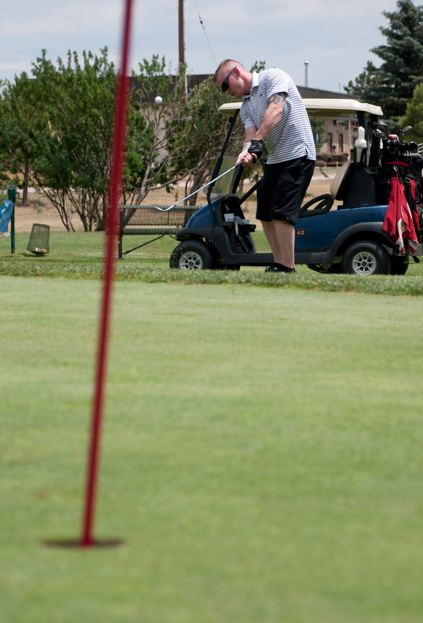 Senior Airman Jonathan Parker, 90th Security Forces Group Tactical Response Force, chips the ball onto the green of Hole 4 on the F. E. Warren Golf Course July 12, 2013. (U.S. Air Force photo by Airman 1st Class Jason Wiese)