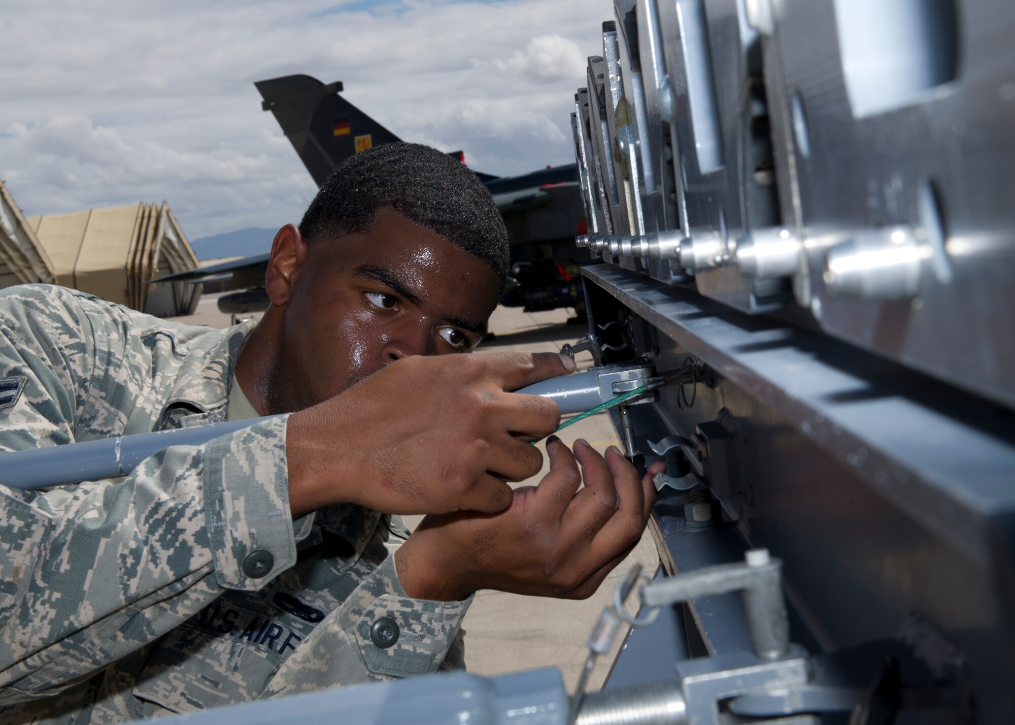 Airman 1st Class Nathan White, 49th Aircraft Maintenance Squadron F-22 Raptor weapons load crew member, secures a rod to a MHU-141 munitions trailer during the second quarter load crew competition at Holloman Air Force Base, N.M., July 19. The F-22 load crew competed against MQ-9 Reaper and German Air Force load crews. For the competition, points are awarded during the weapons loading, tool kit inspection, and uniform inspection. (U.S. Air Force photo by Senior Airman Kasey Close/Released)